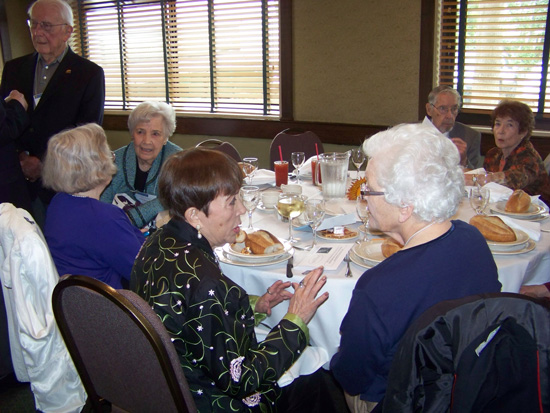 Guest sitting at luncheon table socializing 