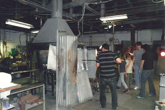 Member putting metal rod in kiln