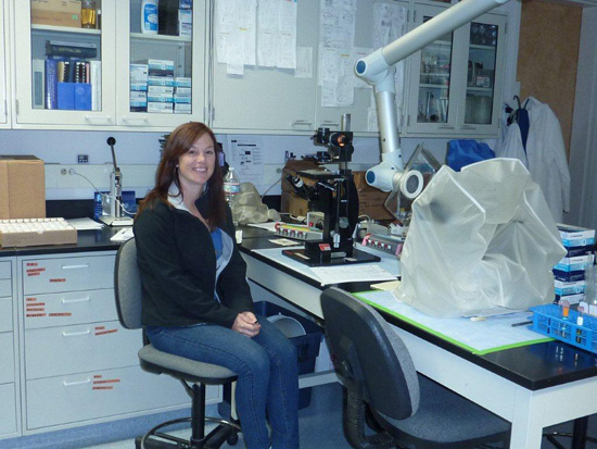 Lab technician in front of a microscope