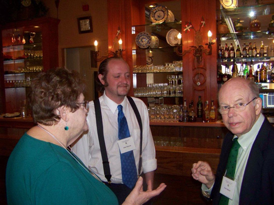 Three guests standing at the 2013 Saint Patricks Day Luncheon looking at the camera