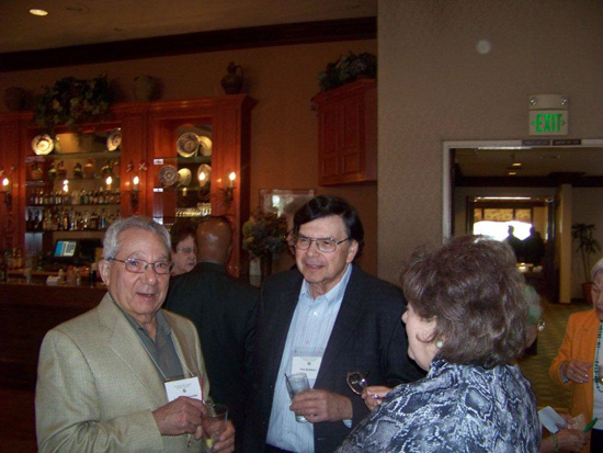 Three guests standing and talking at the 2013 Saint Patricks Day Luncheon looking at the camera