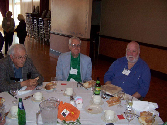 Three guests sitting at the table at the 2013 Saint Patricks Day Luncheon looking at the camera
