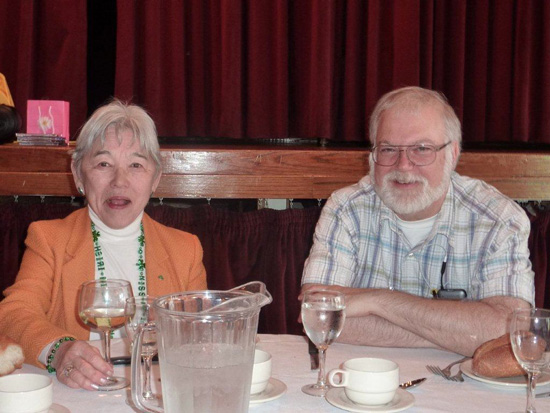 Two Attendees sitting at the table looking at the camera and smiling